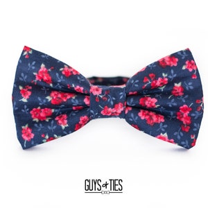 Pode incluir: Uma gravata borboleta azul marinho com padrão floral vermelho.
