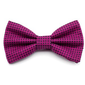 Puede incluir: Una pajarita rosa con un patrón geométrico en blanco y negro.
