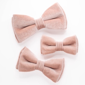 May include: Three velvet bow ties in different sizes, all in a dusty rose color.