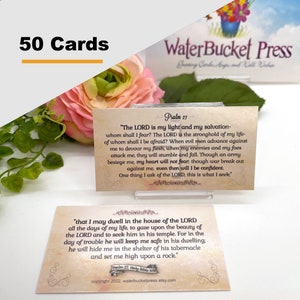 May include: A set of 50 cards with Bible verses printed on them. The cards have a vintage design with text from Psalm 27 and other verses. The cards are displayed with a pink flower and greenery in the background. The text "WaterBucket Press" is visible.