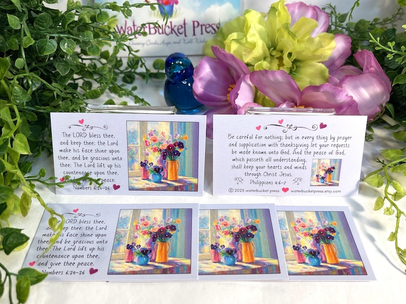 Pode incluir: Cart&otilde;es com arte floral e vers&iacute;culos b&iacute;blicos. Os cart&otilde;es apresentam uma pintura de flores em vasos. O texto nos cart&otilde;es inclui vers&iacute;culos b&iacute;blicos de N&uacute;meros e Filipenses. Os cart&otilde;es s&atilde;o cercados por vegeta&ccedil;&atilde;o e flores.