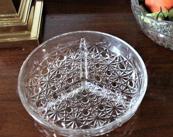May include: A clear glass divided serving dish with a decorative diamond pattern. The dish has three sections.