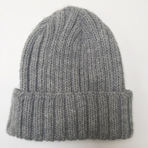 May include: A grey knitted beanie hat with a ribbed texture.
