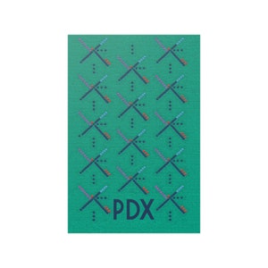 May include: A green background with a repeating pattern of blue, red, and purple lines forming an X shape. The text "PDX" is in the center of the image.