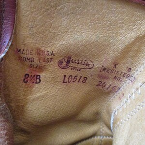 May include: Close-up of the inside of a brown leather boot. The text "MADE IN U.S.A." and "8 B" are visible, along with the brand name "Justin" and style information. The boot's interior is a light tan color.