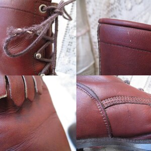 May include: Close-up of a pair of brown leather boots. The boots have laces, metal eyelets, and a fringe detail at the top of the foot. The leather appears worn, with visible stitching and a textured surface.