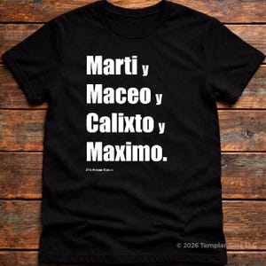 May include: Black t-shirt with white text stacked vertically: Marti y, Maceo y, Calixto y, Maximo. The shirt has a crew neck and short sleeves. The text is in a bold, sans-serif font. The shirt is displayed on a wooden surface.