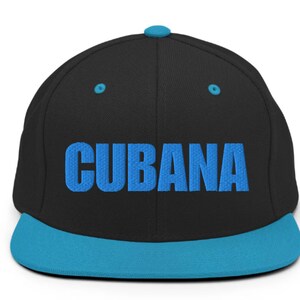 May include: A black and blue baseball cap with the word 'CUBANA' embroidered in blue on the front.
