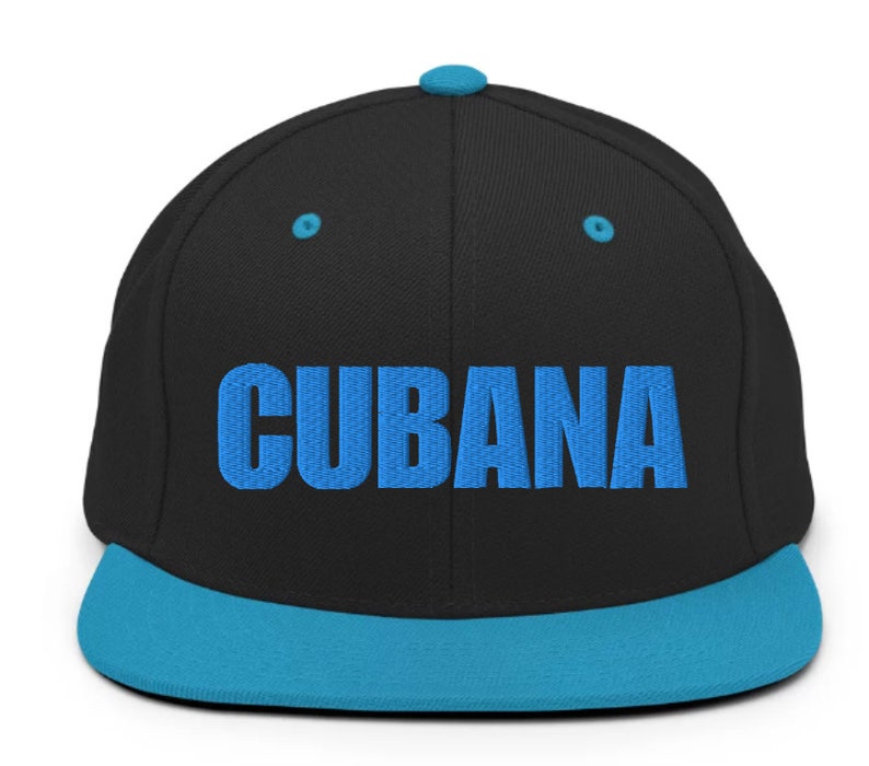 May include: A black and blue baseball cap with the word 'CUBANA' embroidered in blue on the front.