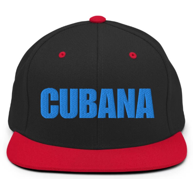 May include: A black and red baseball cap with a blue embroidered word 'CUBANA' on the front.