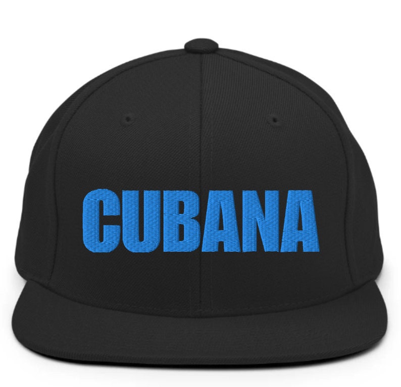 May include: A black and blue baseball cap with the word 'CUBANA' embroidered in blue on the front.