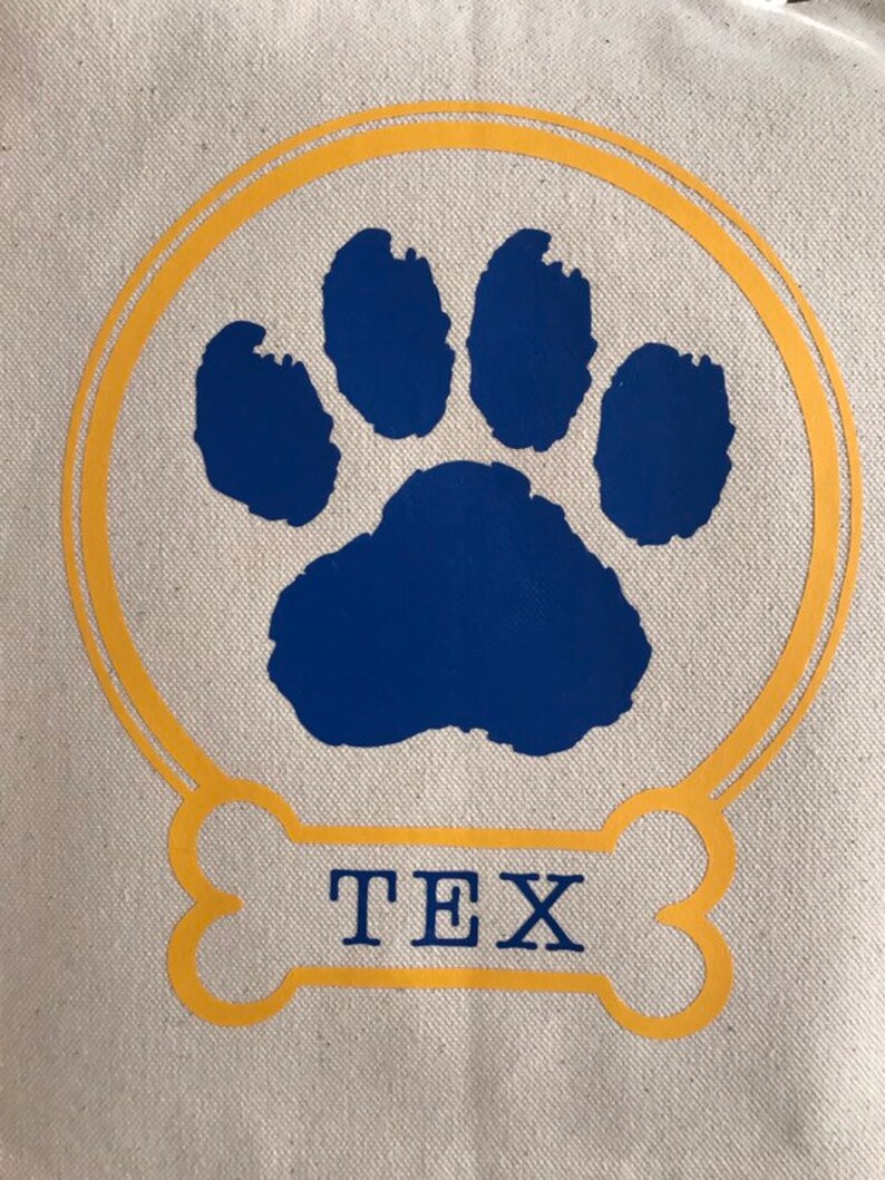 May include: A yellow bone-shaped design with the name "TEX" inside. A blue paw print is inside a double yellow circle.