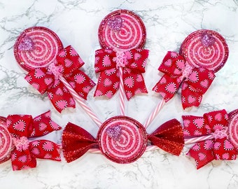 Può includere: Sei lecca-lecca a spirale rosa e rosso con bastoncini bianchi e fiocchi con motivo a cuori rossi e rosa.