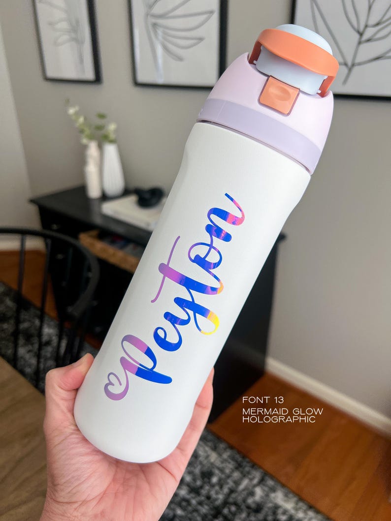 A person's hand holding a white water bottle with the name "Peyton" printed on it in a stylized font.