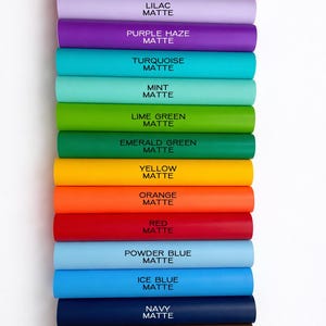 A collection of colorful tubes of matte paint arranged in a row, each tube labeled with a different color.