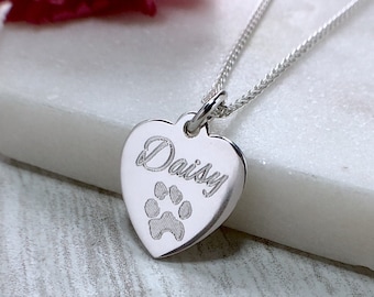 May include: Silver heart-shaped pendant necklace with the name "Daisy" engraved on it and a paw print design.