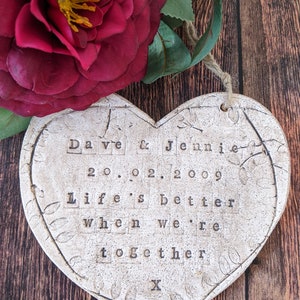 May include: White ceramic heart-shaped ornament with the text "Dave & Jennie 20.02.2009 Life's better when we're together X" in black lettering.