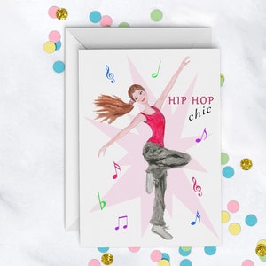 May include: Greeting card with a watercolor illustration of a dancer in a red top and gray pants, with the words "HIP HOP chic". The card is surrounded by musical notes and a pink starburst design. Colorful confetti is scattered around the card.