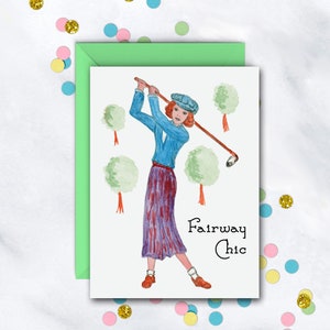 May include: A greeting card with a watercolor illustration of a woman playing golf. The woman is wearing a blue shirt, a purple skirt, and a blue hat. The text on the card reads "Fairway Chic".
