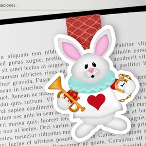 Può includere: Segnalibro a forma di coniglio bianco con un cuore rosso, un colletto blu e un orologio da tasca dorato. Il coniglio tiene una tromba dorata. Il segnalibro è su una pagina di un libro con testo.