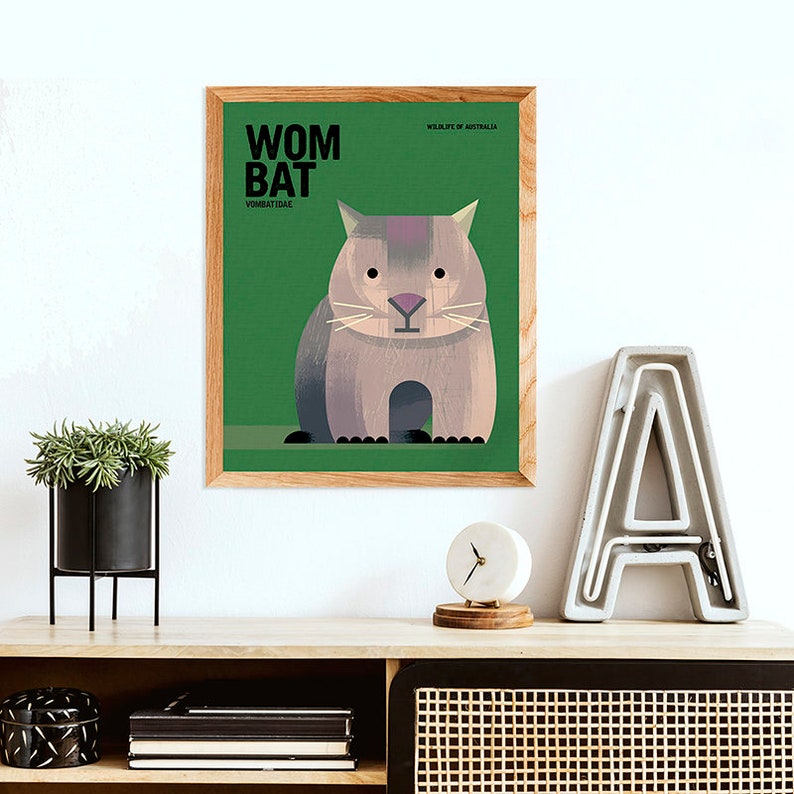 May include: A green framed poster with a brown wombat on a green background. The poster has the text "WOMBAT" in black letters and "WILDLIFE OF AUSTRALIA" in smaller black letters. The poster also has the text "VOMBATIDAE" in smaller black letters.