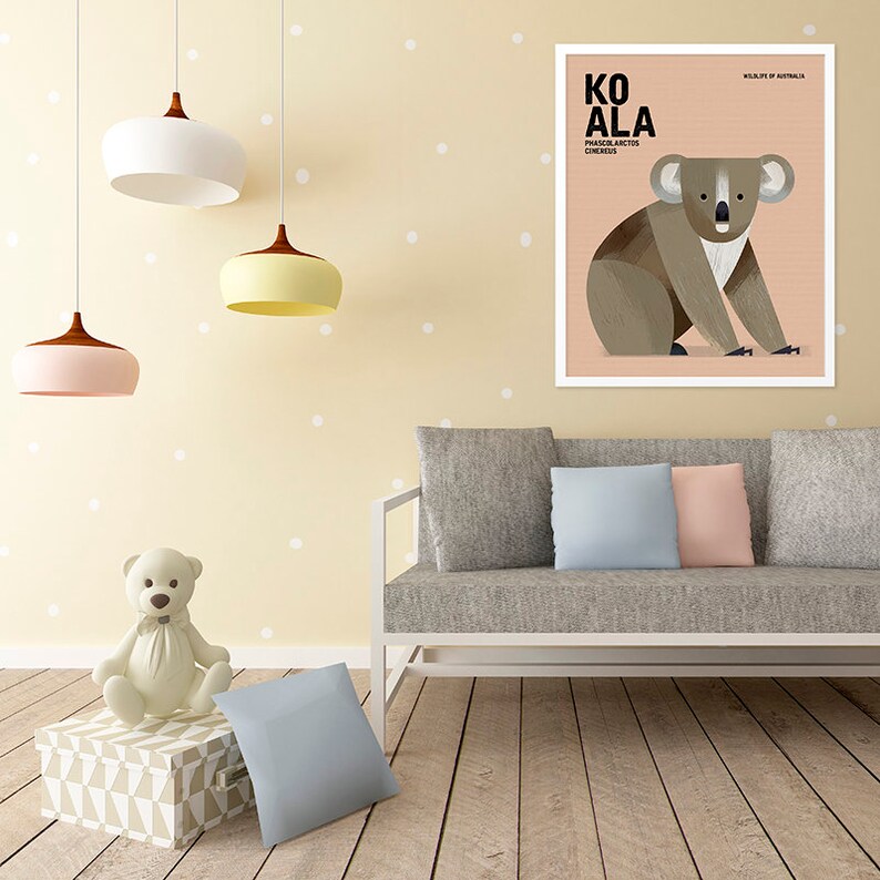 K&ouml;nnte beinhalten: Ein gerahmter Kunstdruck mit einem Koala-B&auml;ren, der den Text "KOALA" und "PHASCOLARCTOS CINEREUS" tr&auml;gt. Die Koala-Illustration ist in Braun-, Grau- und Wei&szlig;t&ouml;nen gehalten und vor einem pfirsichfarbenen Hintergrund platziert. Der Druck wird in einem Wohnzimmer gezeigt.