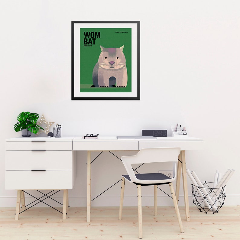 May include: A framed illustration of a wombat, a marsupial native to Australia. The illustration is in a minimalist style with a green background and black text that reads "Wombat" and "FAMILY: VOMBATIDAE".