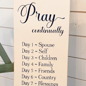 May include: A beige wooden sign with black text that reads "Pray continually" and lists a daily prayer focus for each day of the week. The sign is a stencil only and not a finished sign.