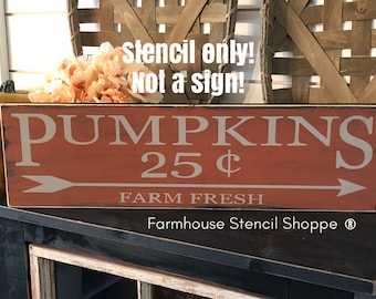 Puede incluir: Un letrero de madera rojo con texto blanco que dice "PUMPKINS 25¢ FARM FRESH" con una flecha blanca apuntando hacia la derecha. El letrero también incluye el texto "Farmhouse Stencil Shoppe ®" en la esquina inferior derecha.