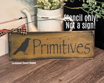 May include: A rectangular wooden sign with the word "Primitives" in a rustic font, featuring a black crow silhouette. The sign has a distressed, aged appearance with a dark border. The text "Stencil only! Not a sign!" is also visible.
