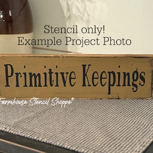 May include: A rectangular wooden sign with the words "Primitive Keepings" in black lettering. The sign has a distressed, aged appearance. The text "Stencil only! Example Project Photo" is above the sign, and "Farmhouse Stencil Shoppe" is below.