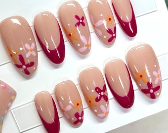 Donkerroze Franse tips, bloemennagels, bloemnagelkunst. Bloemenpers op nagels. Franse tipnagels