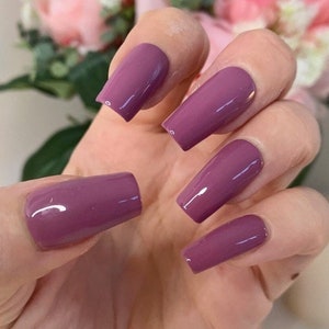 Könnte beinhalten: Ein Set mit sechs mauvefarbenen, sargförmigen Press-on-Nägeln.