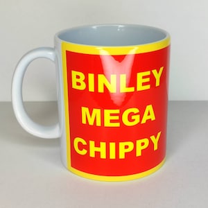 Puede incluir: Taza de cerámica blanca con un diseño rojo y amarillo. El diseño presenta el texto "Binley Mega Chippy" en letras amarillas.