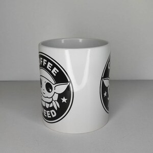Pu&ograve; includere: Tazza da caff&egrave; in ceramica bianca con una grafica in bianco e nero di un personaggio dei cartoni animati con il testo "Coffee and Weed" in un cerchio.