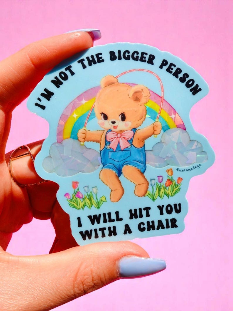 May include: A light blue sticker with a cartoon bear jumping rope in front of a rainbow. The sticker has the text "I'm not the bigger person, I will hit you with a chair."