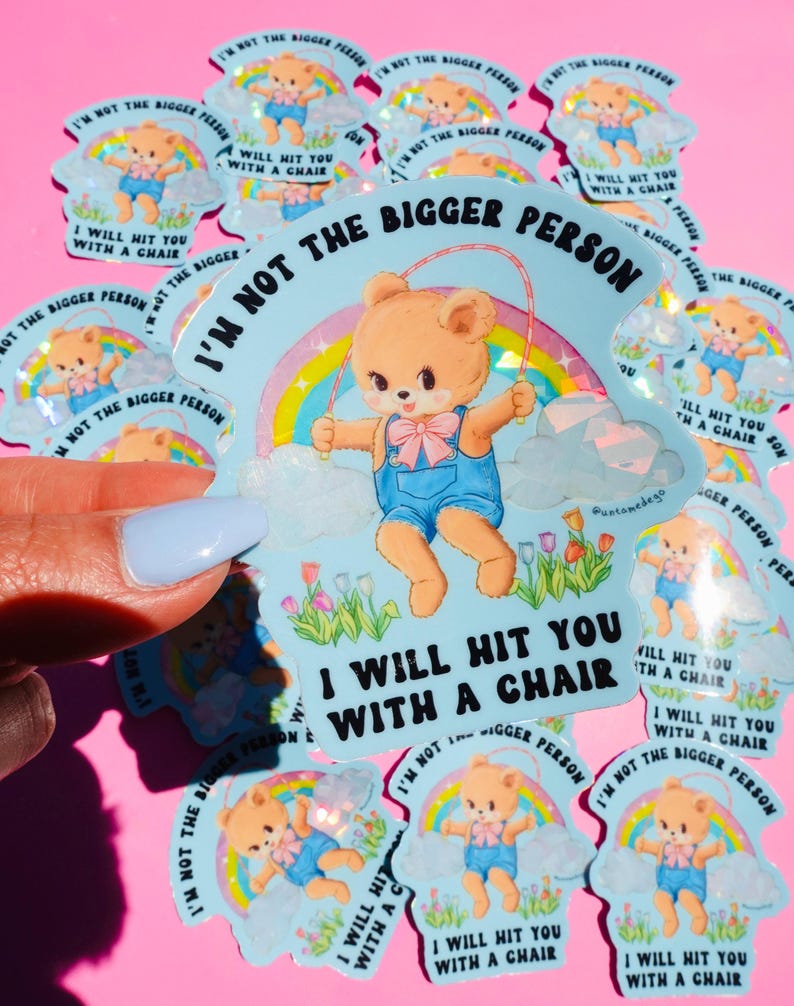May include: A collection of light blue stickers featuring a cartoon teddy bear skipping rope in front of a rainbow. The text on the sticker says "I'M NOT THE BIGGER PERSON, I WILL HIT YOU WITH A CHAIR."