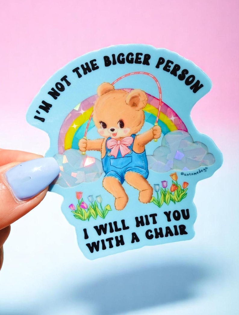 May include: A light blue sticker with a cartoon bear skipping rope in front of a rainbow. The bear wears blue dungarees and a pink bow tie. Text reads "I'M NOT THE BIGGER PERSON I WILL HIT YOU WITH A CHAIR."