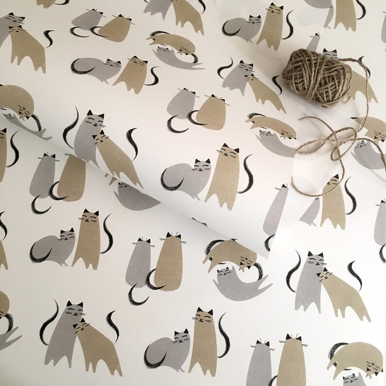 May include: White wrapping paper with a repeating pattern of grey and brown cats. The cats are in various poses, including cuddling and sitting.