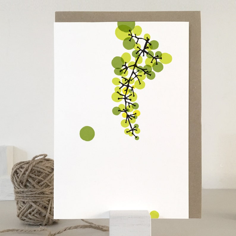 May include: A white card with a green and yellow abstract design of a vine with circles. The vine is on the right side of the card and there is a single green circle on the left side of the card.