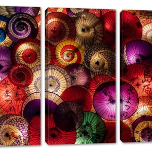 May include: A close-up of a wall covered in colorful Japanese paper umbrellas. The umbrellas are arranged in a random pattern and are all different sizes and shapes. Some of the umbrellas have Japanese characters written on them.