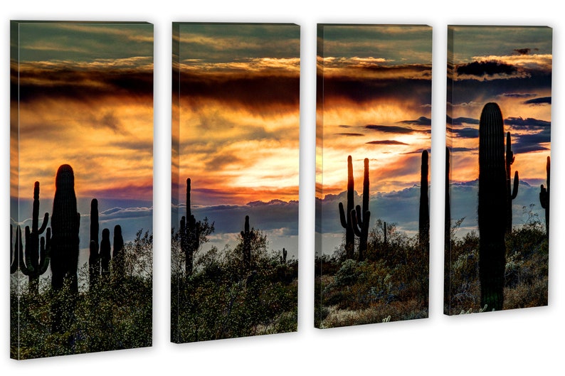 May include: A four-panel canvas print depicting a desert sunset. Silhouetted saguaro cacti stand in the foreground against a backdrop of a vibrant orange and yellow sky with dramatic cloud formations. The artwork evokes a sense of the American Southwest.