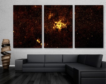 Puede incluir: Una impresión en lienzo de tres paneles que presenta un primer plano de una nebulosa en el espacio. La nebulosa es de un color amarillo dorado brillante y está rodeada de un fondo negro oscuro con estrellas dispersas.