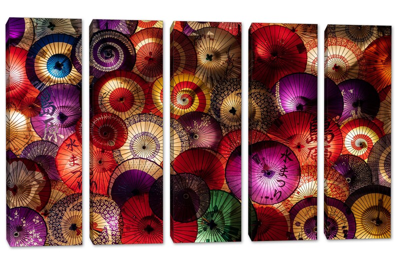May include: A multi-panel wall art print featuring a close-up of colorful Japanese paper umbrellas. The umbrellas are arranged in a circular pattern, with the handles facing outward. The umbrellas are made of a thin, translucent paper, and they are decorated with a variety of patterns and designs. The colors of the umbrellas are vibrant and eye-catching, and they create a sense of movement and energy.