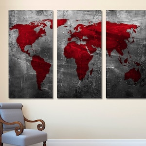Puede incluir: Un conjunto de tres lienzos de pared con una mapa del mundo rojo sobre un fondo gris texturizado.