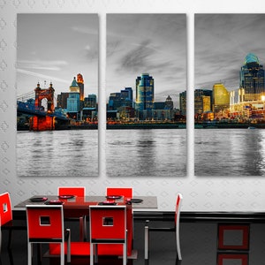 Pu&ograve; includere: Una foto panoramica in bianco e nero dello skyline di Cincinnati al tramonto. La foto &egrave; divisa in tre pannelli, con il pannello sinistro che mostra il ponte sospeso Roebling, il pannello centrale che mostra lo skyline del centro citt&agrave; e il pannello destro che mostra il Great American Ball Park.