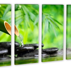May include: A bamboo shoot pours water over smooth black stones in a zen garden setting. The background is a blurred image of green leaves.