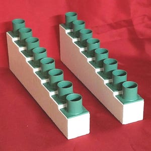 May include: Two white foam blocks with multiple green plastic candle holders. Each block has 8 candle holders arranged in a stepped pattern.