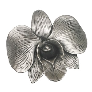 May include: A silver-toned metal orchid flower ornament. The flower has a detailed, textured surface and is a realistic representation of an orchid.