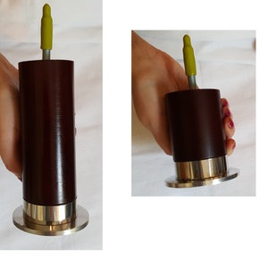May include: A dark brown wooden furniture leg with a silver metal base and a yellow plastic cap on top.